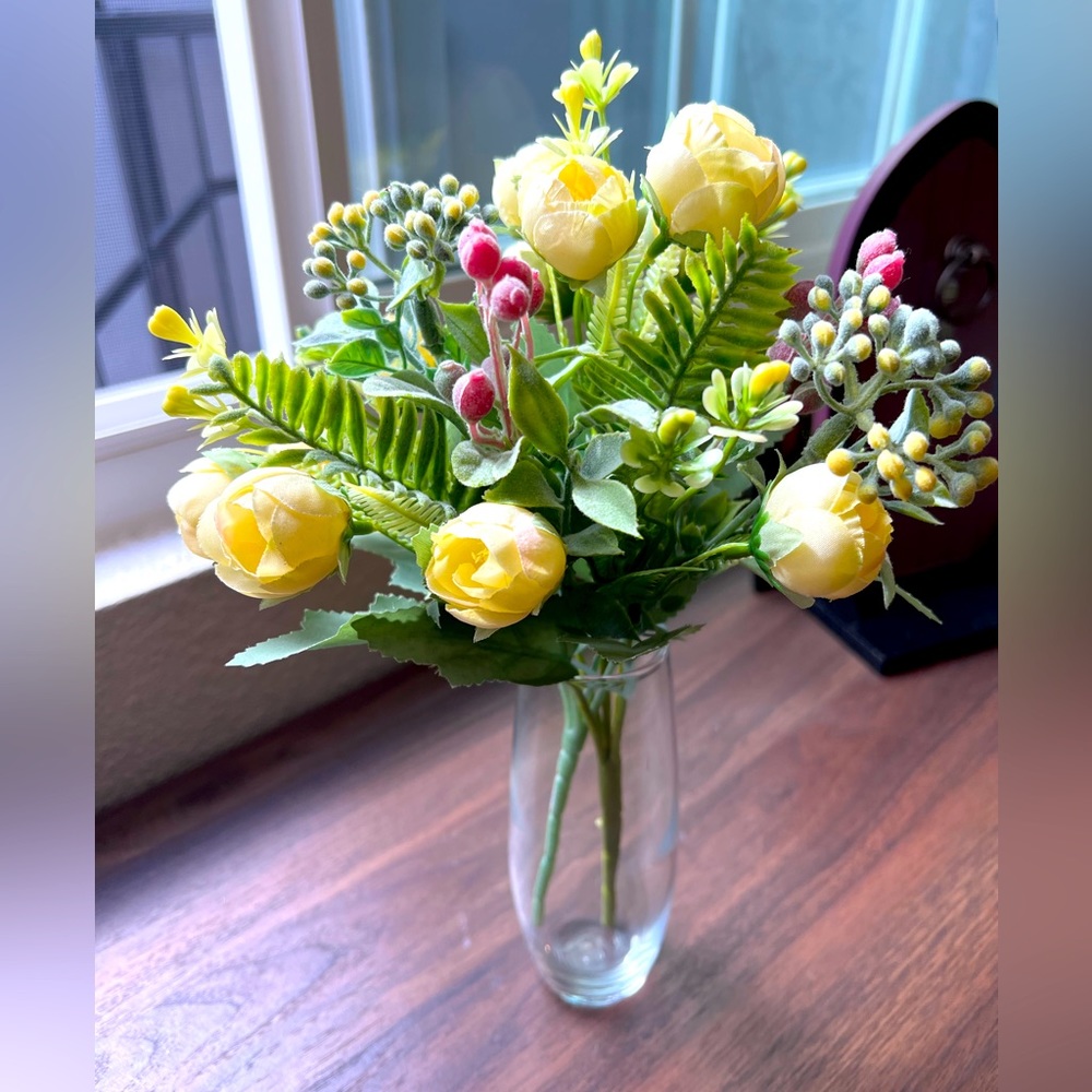 Faux flowers lights yellow roses with foliage in a vase